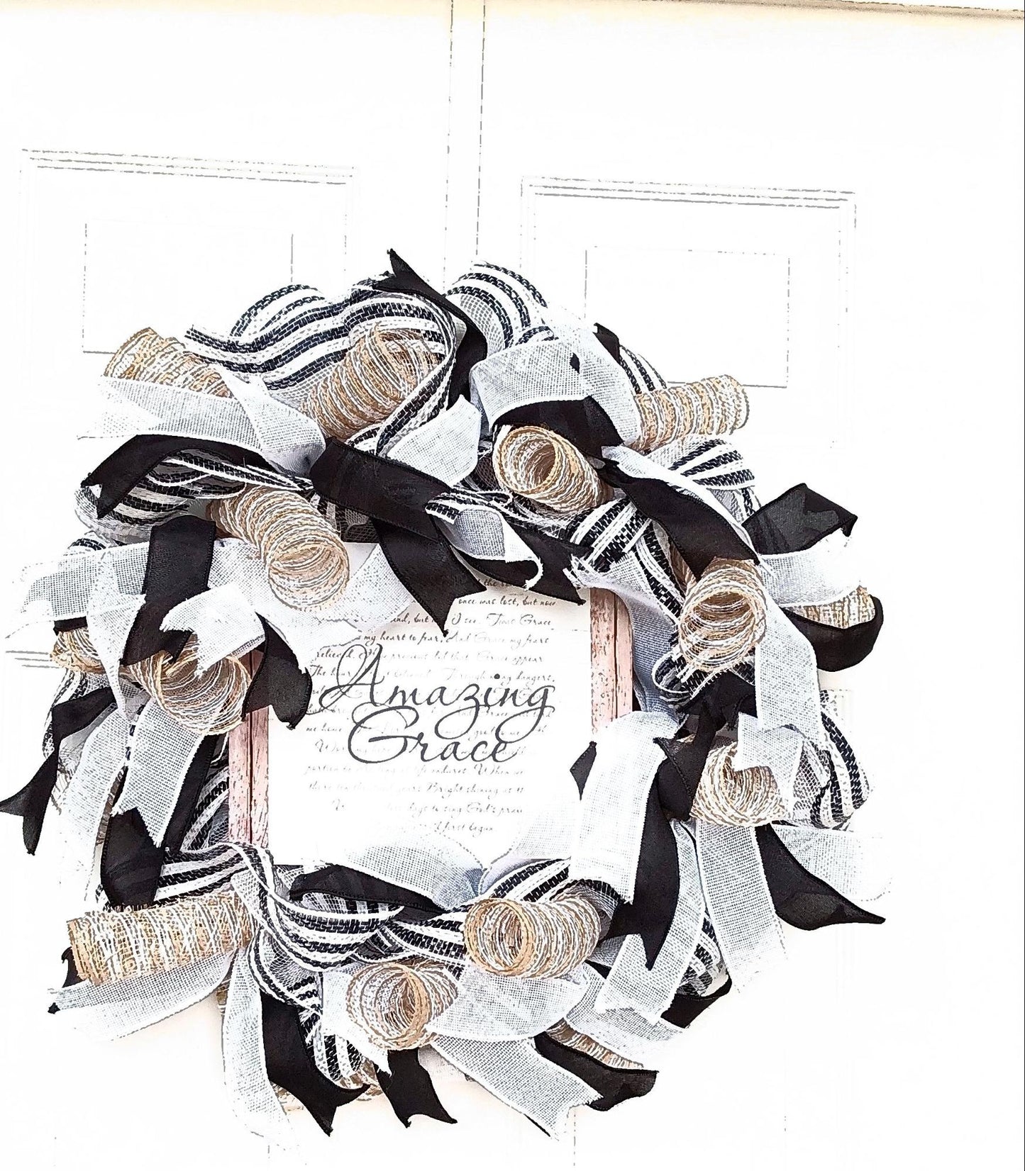 A white, gold, and black wreath with "Amazing Grace" at the center.