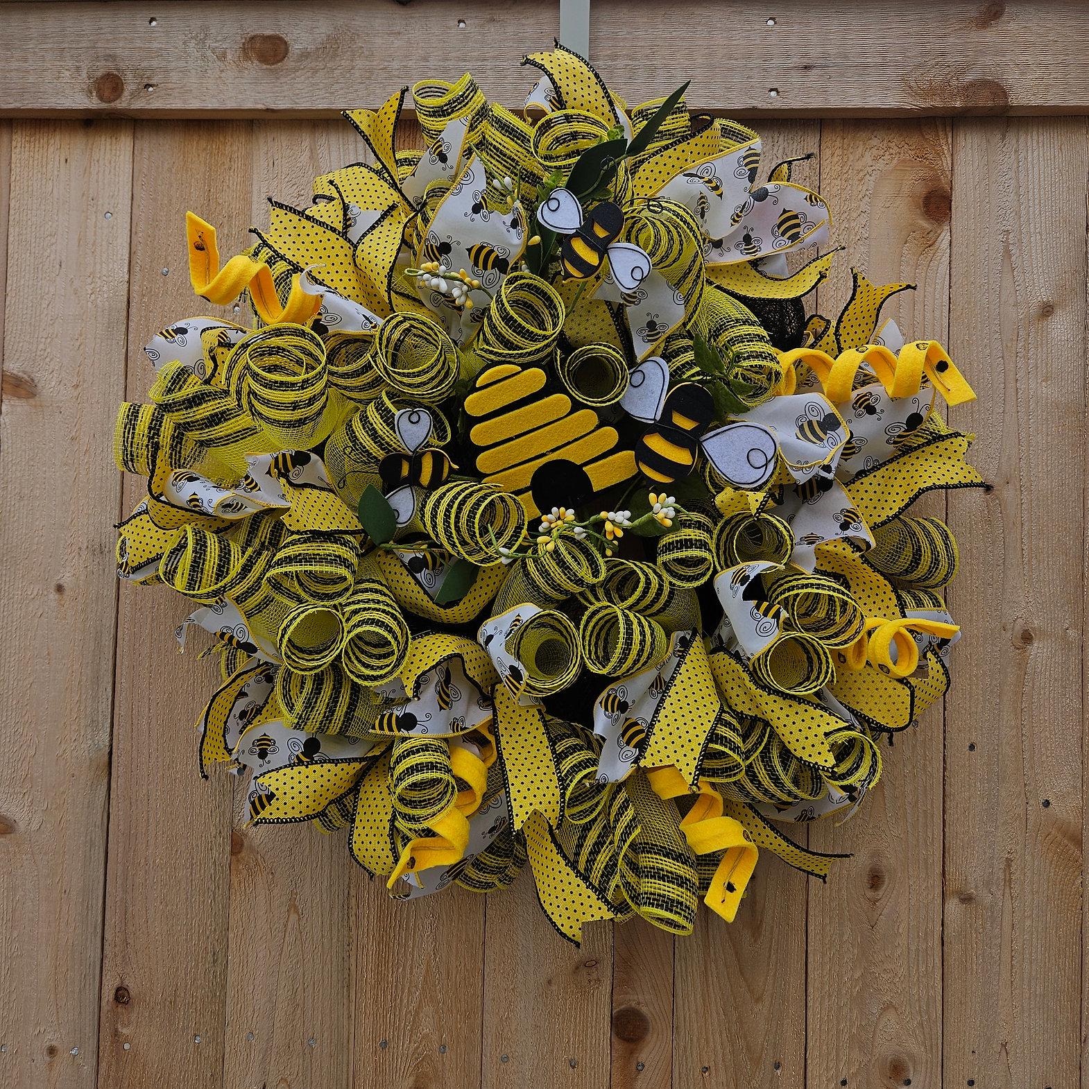 Beehive-inspired wreath with layers of yellow and black mesh and accented with yellow polka dot and bee-theme ribbons