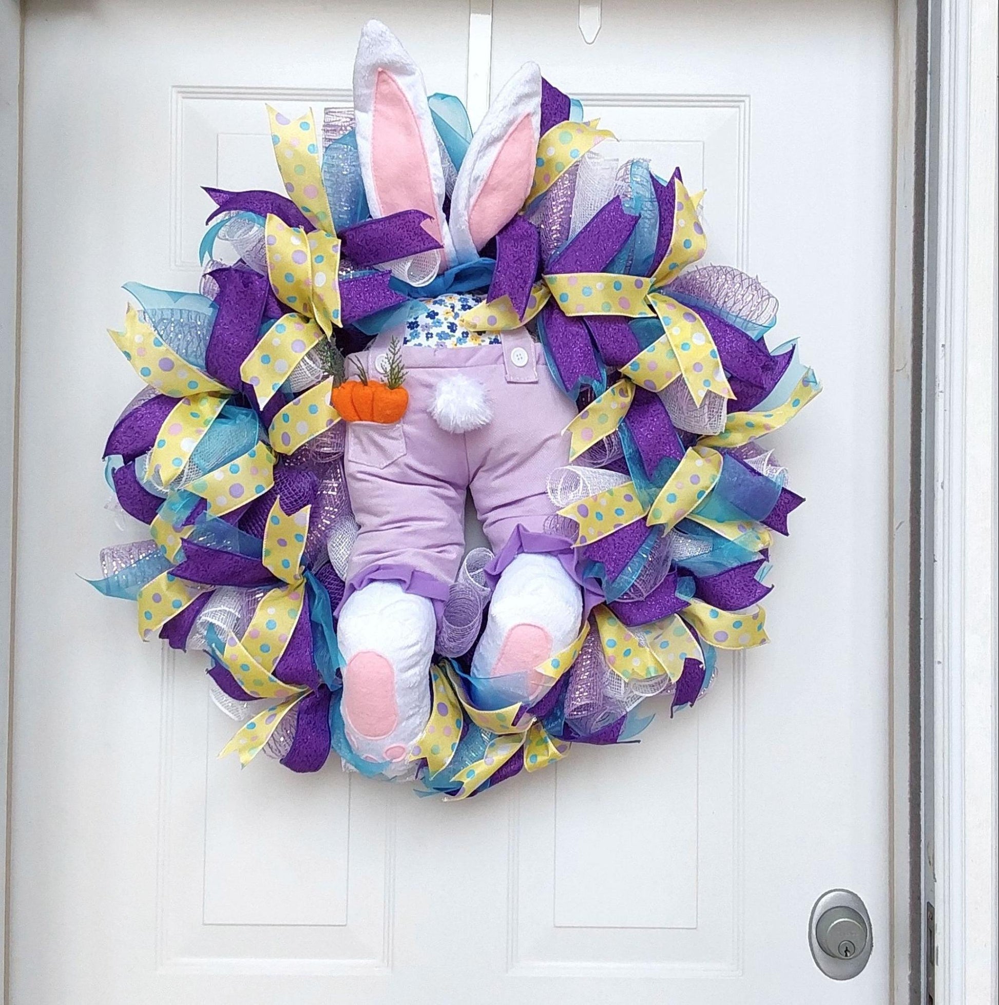 An Easter wreath featuring a bunny booter at its center.