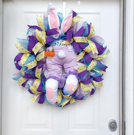 An Easter wreath featuring a bunny booter at its center.