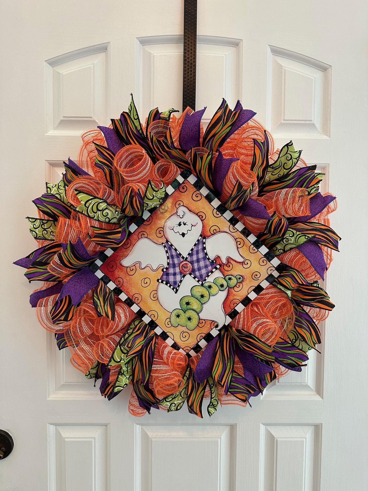 A mesh and ribbon wreath with a ghost at the center with the word booooo