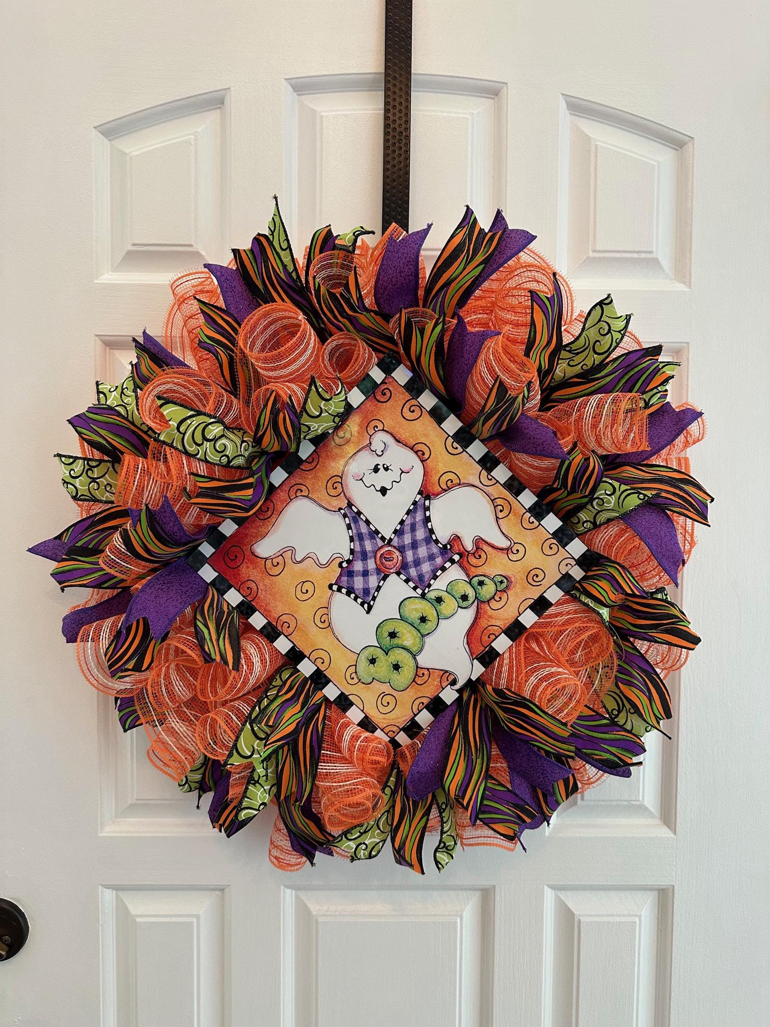 A mesh and ribbon wreath with a ghost at the center with the word booooo