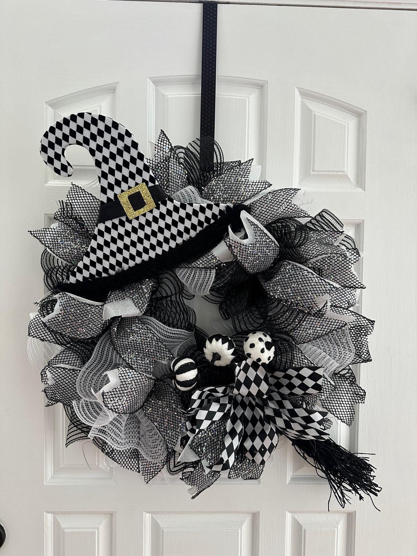 Black and white wreath with mesh and a witch's hat.