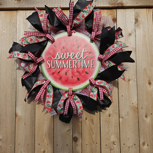 A ribbon wreath with a watermelon circle at the center with the words "sweet summertime"